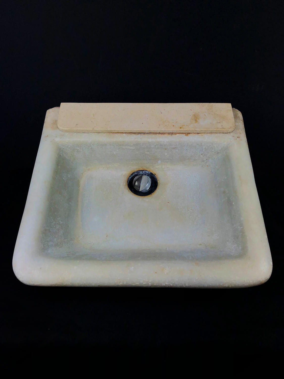 A carved white marble hand sink / basin