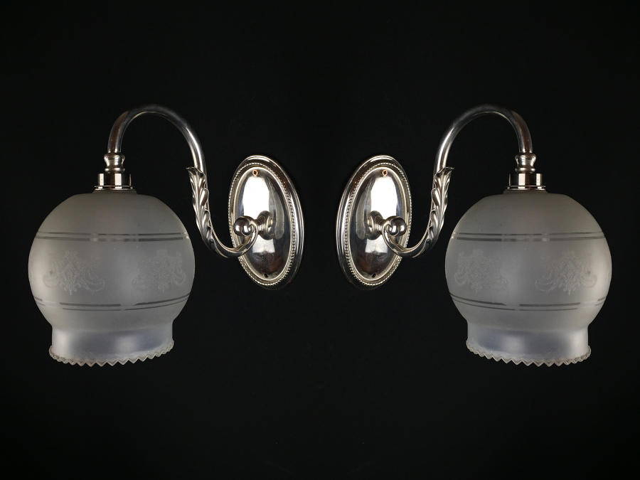 A pair of Edwardian silver plated single arm wall lights