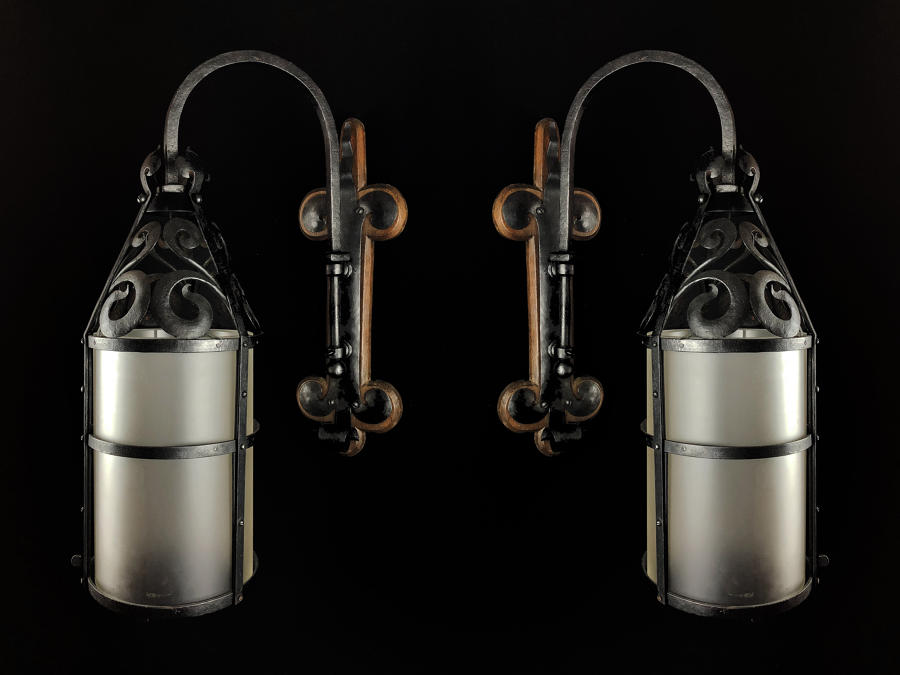 A pair of wrought iron wall lanterns