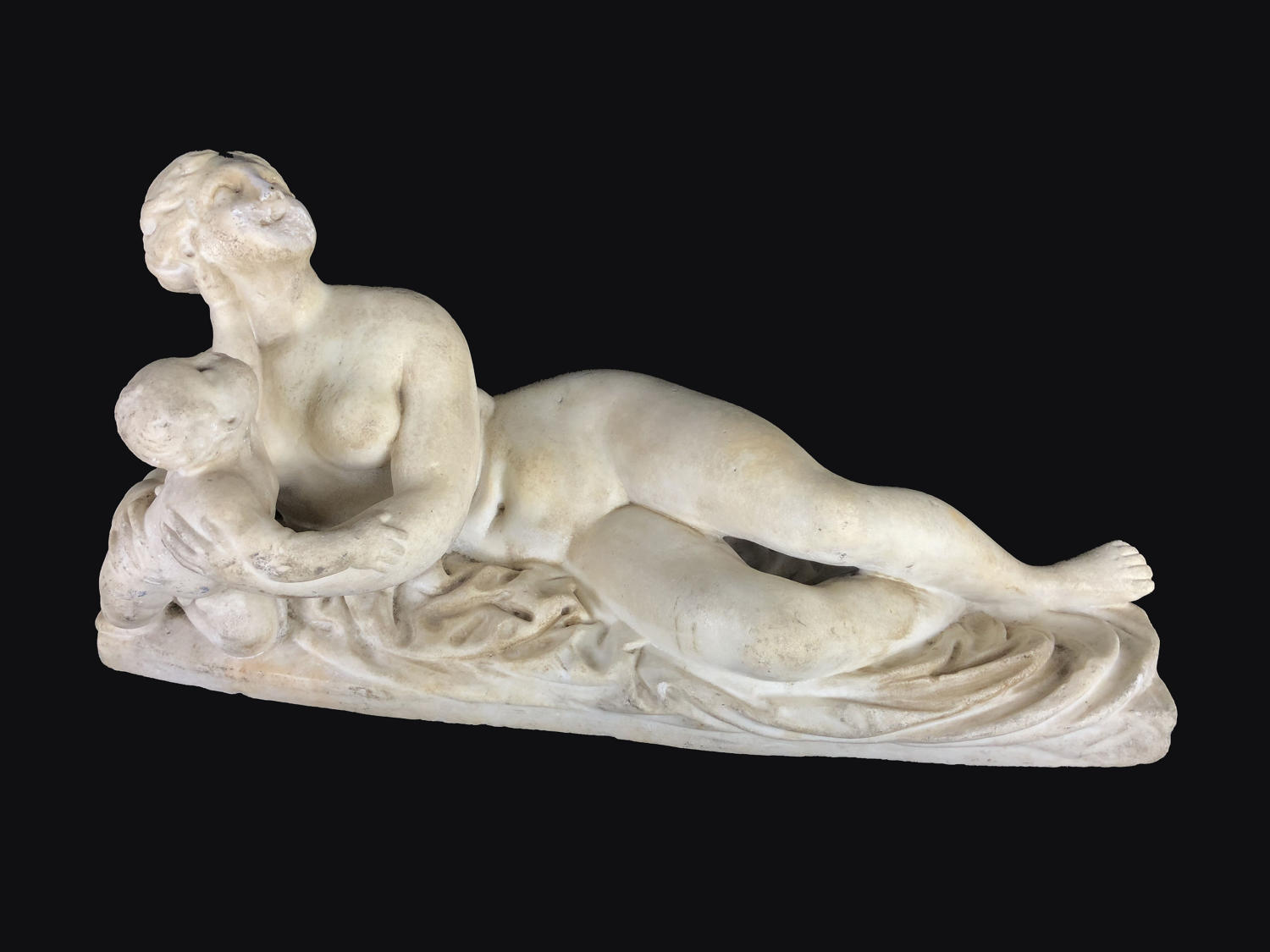 A plaster figure of a reclining woman and baby