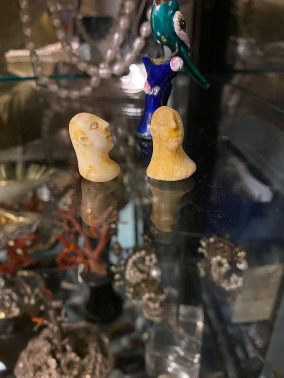 A pair of miniature near lithic style heads