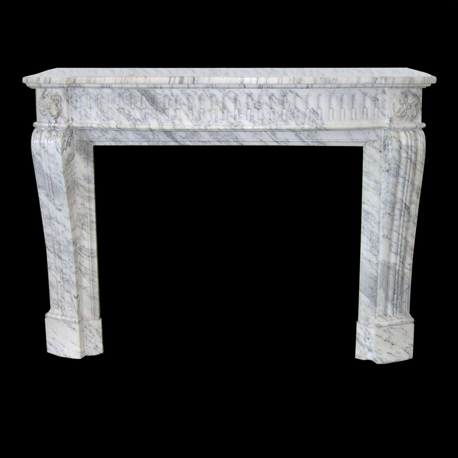 A carved Louis XVI style fire surrounds in Arabascato marble