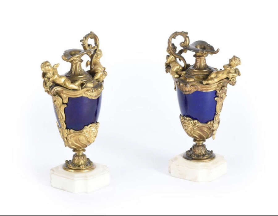 A pair of ormolu and severs style pottery ewers