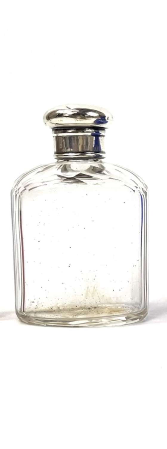 A scent bottle with a silver head